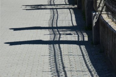 Demir çit ve duvarlar tuğla kaldırımdaki gölgeler