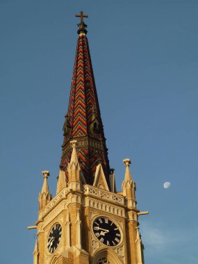 Sırbistan 'ın Novi Sad kentindeki kilise kulesi, gökyüzünde saat ve ay var