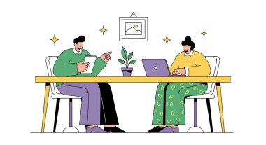 İki kişi sarı bir masada oturuyor, biri tabletli, diğeri dizüstü bilgisayarlı, masada bitki ve resim var..