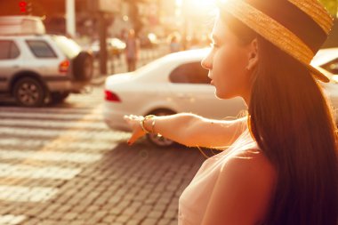 Moda kız güneşli bir taksi yakalar