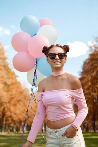 Hermosa chica en gafas de sol con globos sonriendo — Foto de Stock