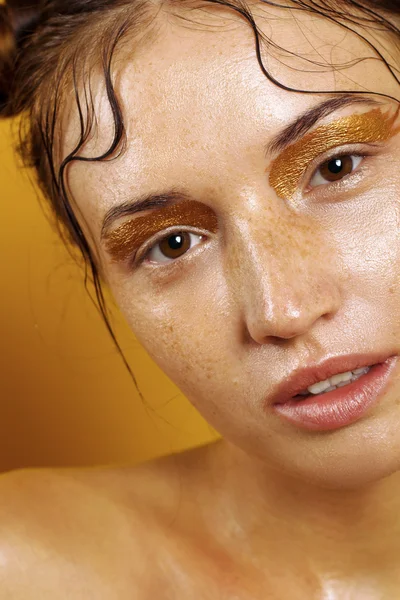 Potret seorang gadis cantik dengan latar belakang kuning dengan efek kulit basah — Stok Foto