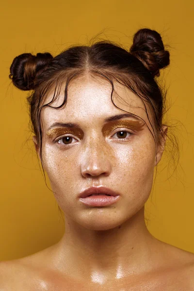 Portréja egy gyönyörű lány, egy sárga háttér, és a hatása a nedves bőr — Stock Fotó