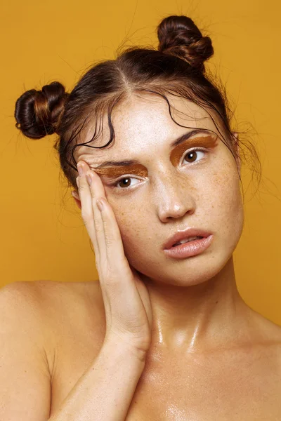 Portrait of a beautiful girl on a yellow background with the effect of wet skin Stock Image
