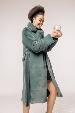 Makyajlı, kürklü, Noel süsleriyle poz veren güzel ve mutlu bir kız.