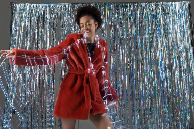 Makyajlı, kürklü, Noel süsleriyle poz veren güzel ve mutlu bir kız.