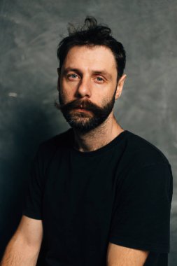 Arka planda sakalı ve bıyığı olan cesur bir adamın portresi.