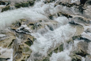 Kayaların ve taşların arasındaki kış deresi