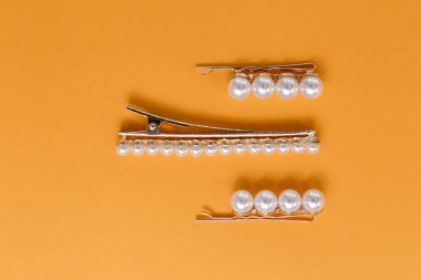 Sarı arka planda bir saç stilisti için aksesuar ve saç tokaları kompozisyonu