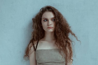 Büyük mavi gözleri ve kıvırcık saçları olan güzel kız.