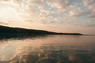 Gün batımında güzel bir manzara, suyun manzarası ve göldeki gökyüzünün yansıması.