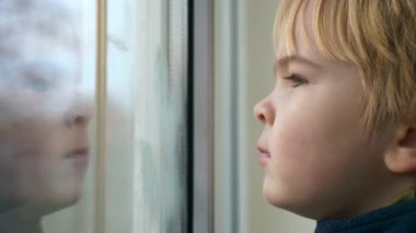 Şirin Çocuk Düşünceli Surat. Ciddi Çocuk Bekliyor, Pencereden Bakıyor ve Düşünüyor. 2x Yavaş çekim 60 FPS 4K