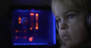 Kulaklıklı Çocuk Surat. Çocuk Bilgisayar Monitöründe Video Filmi İzliyor. Doğal Samimi Tepkiler