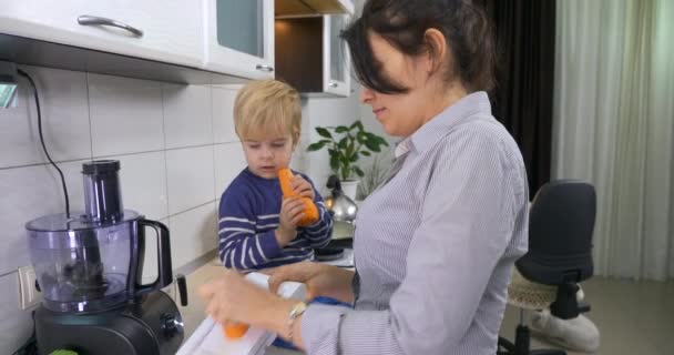 Cute Little Child Eats Big Carrot Duduk Atas Meja Dapur — Stok Video