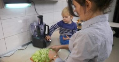 Kadın, Napa Cabbage 'ı mutfak bıçağıyla kesiyor. 4K ile Vejetaryen Vejetaryen Yemeği hazırlamakla meşgul ev hanımı.