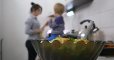 Salata Çanağı 'nı yakın plan çek. Bulanık Arkaplan 'da Anne Bakımı Meşgul Vejetaryen Vejetaryen Sağlıklı Yemekler Evde 4K' da Mutfakta Çocukla