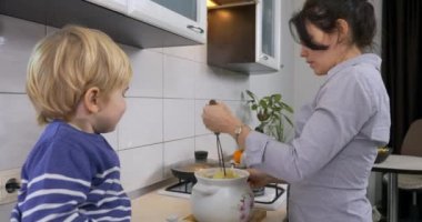 Anne ve Oğlu Patates Püresi Pişiriyor. Ev hanımı 4K 'daki Mutfakta Çocukla Vejetaryen Vejetaryen Yemeği Hazırlıyor
