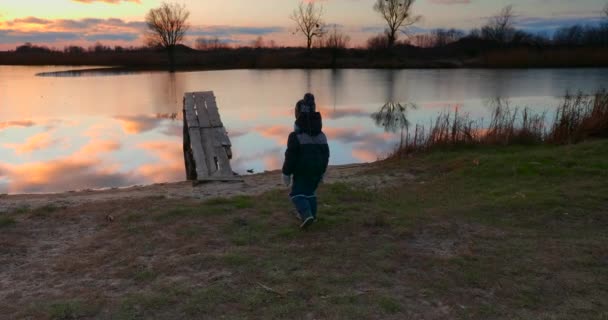 Dziecko Idzie Myśląc Pobliżu Rzeki Oglądam Sunset Sky Reflection Water — Wideo stockowe