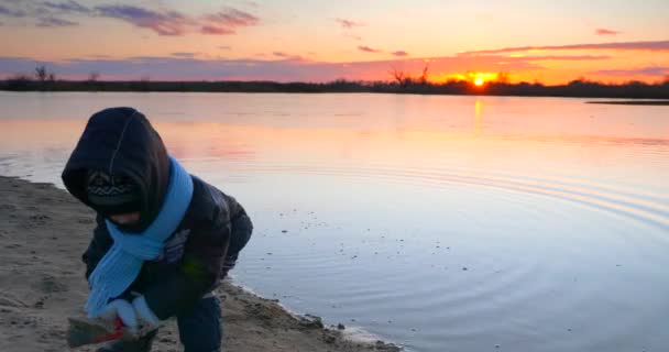 Παιδί Ρίχνει Άμμο Στο Νερό Κοντά Ξύλινη Προβλήτα Αλιείας Στη — Αρχείο Βίντεο