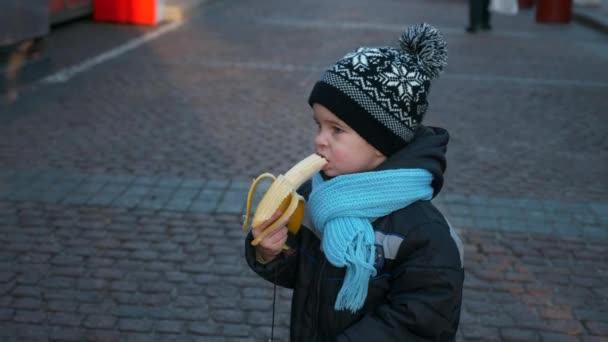Głodne Samotne Dziecko Banana Bożonarodzeniowym Rynku Stojąc Samotnie Zimowe Wakacje — Wideo stockowe