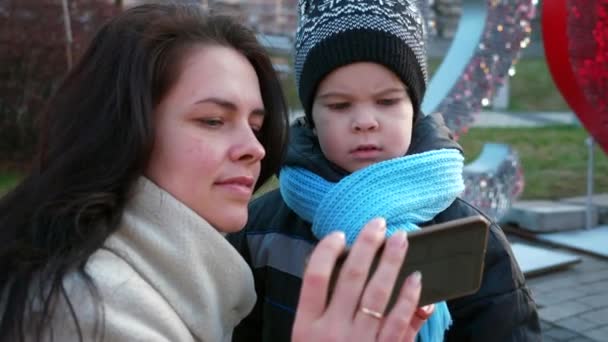Mutter Zeigt Sohn Gerade Aufgenommene Fotobilder Mit Smartphone Beim Neujahrszeichen — Stockvideo
