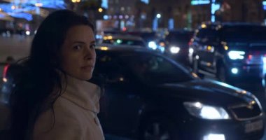 Endişeli Ciddi Kadın Şehir Caddesinde. Bulanık arka planda Polis Acil Işıkları yanıp sönüyor. Akşam Gecesi Karanlık