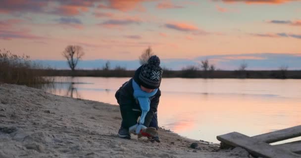 Dziecko Rzuca Piasek Wody Pobliżu Drewnianego Molo Rybackiego Brzegu Jeziora — Wideo stockowe