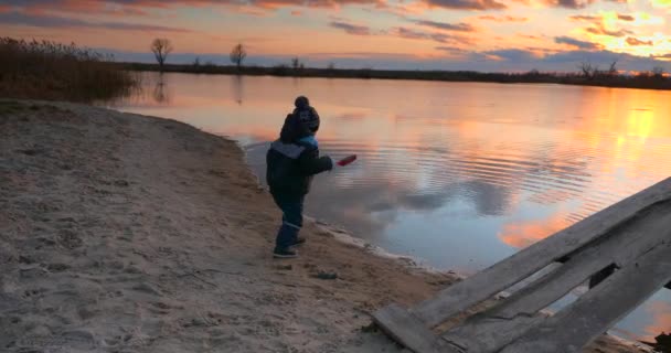 Dziecko Rzuca Piasek Wody Pobliżu Drewnianego Molo Rybackiego Brzegu Jeziora — Wideo stockowe