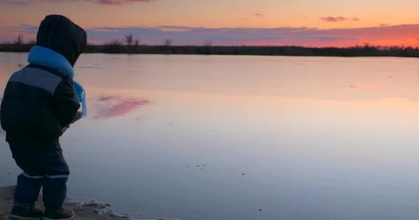 Dziecko Rzuca Piasek Wody Pobliżu Drewnianego Molo Rybackiego Brzegu Jeziora — Wideo stockowe