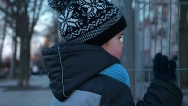 Sad Serious Child Hits Shakes Metal Fence Lattice City Evening — Stock Video