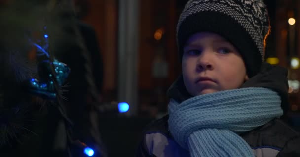 Serious Child Stands Christmas Tree Thinking Dreaming Regarder Regardant Arrière — Video
