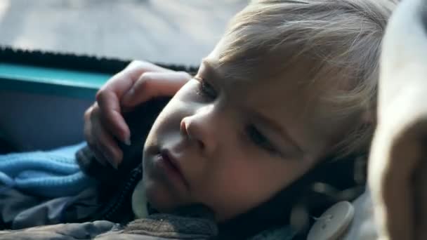 特写累坏了的儿童脸 儿子躺在母亲的手上乘公共汽车旅行 慢动作4K — 图库视频影像
