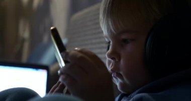 Yakın plan Çocuk Surat. Küçük Çocuk Smartphone 'da çizgi film izliyor. Yürüyen bebek Koltukta oturuyor