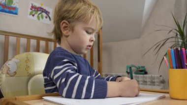 Küçük Çocuk Keçeli kalemle çizim yapmayı öğreniyor. Evde Çocuk Eğitimi. Yaratıcı Anaokulu Çalışması. 2x Yavaş çekim 60 fps 4K
