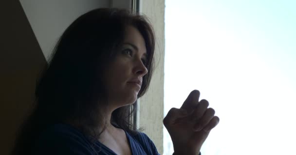 Θλιβερή Γυναίκα Στέκεται Και Σκέφτεται Περιμένοντας Κοιτάζοντας Έξω Από Παράθυρο — Αρχείο Βίντεο