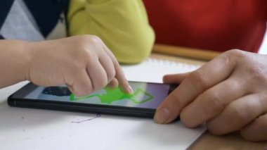 Boy Smartphone Touch ekranında resim yapmayı öğreniyor. Anne Oğul 'a öğretiyor. Evde Çocuk Eğitimi. Parmak dokunmatik ekranda. 2x Yavaş çekim 60 fps 4K