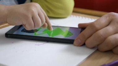 Boy Smartphone Touch ekranında resim yapmayı öğreniyor. Anne Oğul 'a öğretiyor. Evde Çocuk Eğitimi. Parmak dokunmatik ekranda. 2x Yavaş çekim 60 fps 4K
