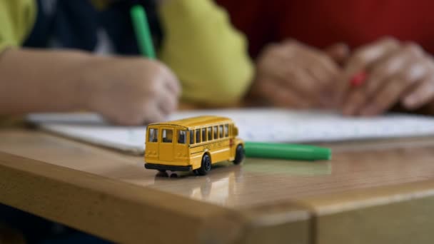 Close Toy School Bus Escritorio Sobre Fondo Borroso Mujer Enseñando — Vídeo de stock