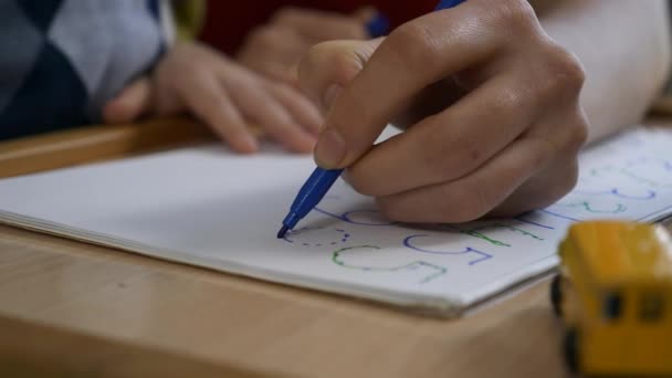 母は息子の手紙と数字を教えています 少年はフェルト先端のペンで描くことを学ぶ 家庭での児童教育 2倍スローモーション60 Fps — ストック動画
