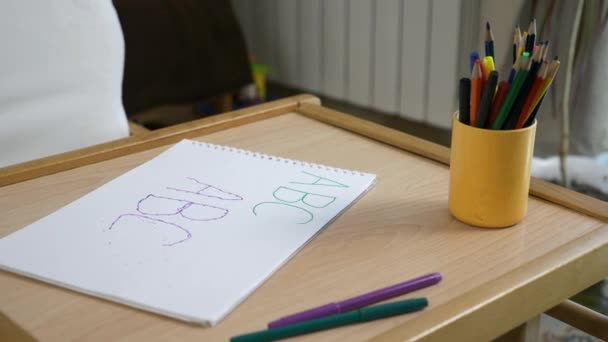 儿童用笔在纸上写的特写信 房间里的空桌子上有铅笔 家庭教育 模糊的背景图片床 2X慢动作60 Fps — 图库视频影像