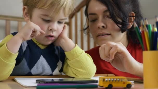 男孩学习在智能手机触摸屏上画画 母亲教儿子 家庭教育 手指在触摸屏上2X慢动作60 Fps — 图库视频影像