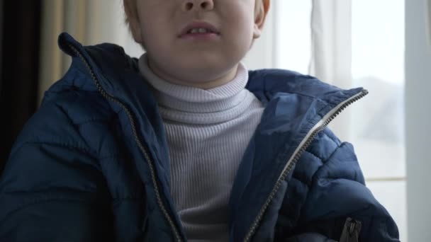 息子はジッパーでジャケットをファスナーを助けるために母に尋ねる 冬の服装をした少年 子ジップファスナーでジップ 2倍スローモーション60 Fps — ストック動画