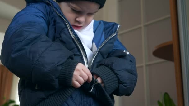 小孩拉链用拉链系紧他的夹克 穿着冬装的小男孩用拉链紧固件拉链 2X慢动作60 Fps — 图库视频影像