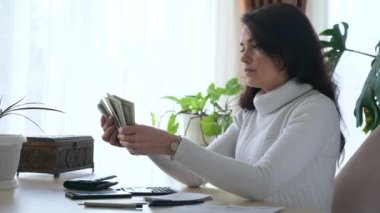 Faturalar Vergi Planlama Aile Bütçesi 'nde çalışırken kadınlar para sayıyor. Ofis Masası 'ndaki ev hanımı için endişelendim. 2x Yavaş çekim 60 fps 4K