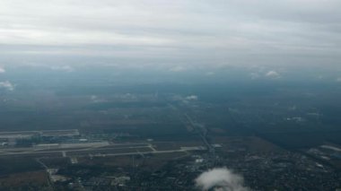 Şehir Havaalanı Terminalleri üzerinde uçan yolcu jeti. Uçak Uçağı Penceresi 'nden görüntü. Havadan çekim. Ukrayna, Kyiv, Boryspil, KBP. 2x Yavaş çekim 60 FPS 4K 