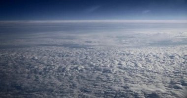 Cloudy Blue Sky 'ı yolcu jetindeki pencerenin penceresinden izle. Bulutların Üzerinde Uçan Uçak