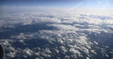 Cloudy Blue Sky 'ı yolcu jetindeki pencerenin penceresinden izle. Bulutların Üzerinde Uçan Uçak