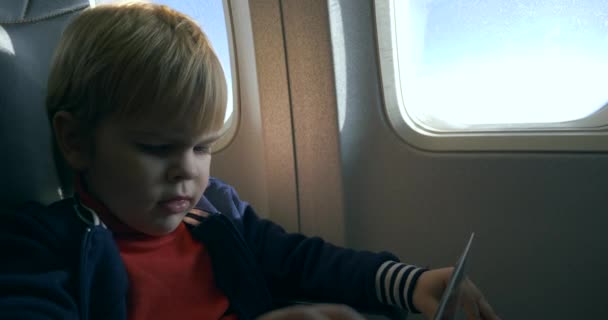 Маленький Хлопчик Читає Книгу Перегляду Меню Пасажирському Місці Борту Літака — стокове відео