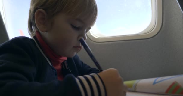Mały Chłopiec Rysuje Paint Book Fotelik Dziecięcy Miejscu Pasażera Pokładzie — Wideo stockowe