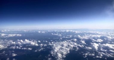 Cloudy Blue Sky 'ı yolcu jetindeki pencerenin penceresinden izle. Bulutların Üzerinde Uçan Uçak